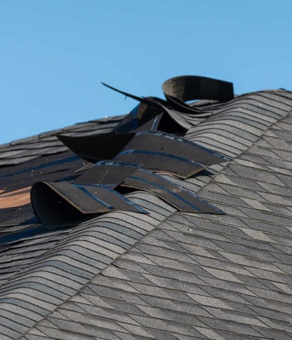 A roof that has wind damage and will require the owner to file an insurance claim for emergency roof repair
